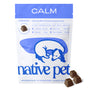 A white bag labeled “Calm” from Native Pet, featuring an illustration of a sleeping dog, contains Native Pet’s Calm Chews Supplement for Dogs—an anxiety supplement—with several brown air-dried chicken chews displayed in front of the bag.