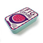 The Neighborgoods Soy Wax Candle in a rectangular sardine tin with a label depicting a fig and the text FIG candle, 100% soy wax, fruity and cozy with notes of amber.
