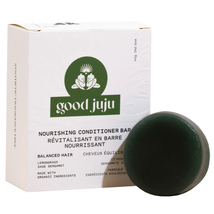 A round, dark green Nourishing Conditioner Bar for Balanced/Normal Hair from Good Juju Body & Home sits before a white box highlighting all-natural ingredients, including coconut oil, for healthy, nourished hair.