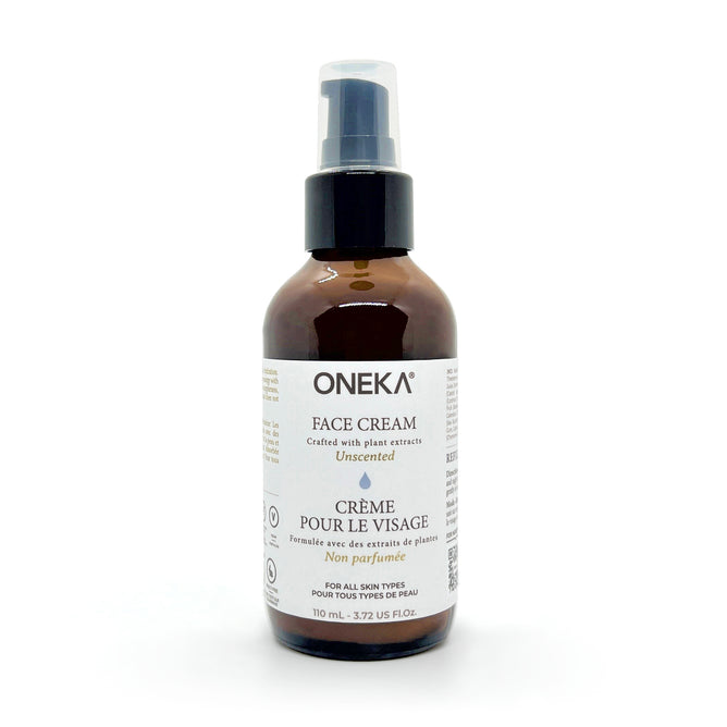 A 110 mL brown bottle of Oneka Face Cream with a black pump and white bilingual label. This unscented, hydrating cream suits all skin types and provides organic skincare.