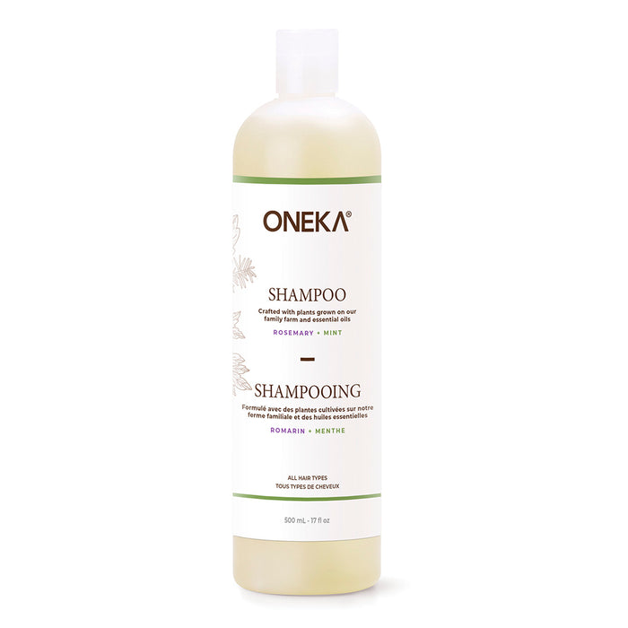 A 500 ml bottle of Oneka Shampoo - Rosemary & Mint features a white label with English and French text, green accents, and a white flip-top cap on a light-colored bottle.
