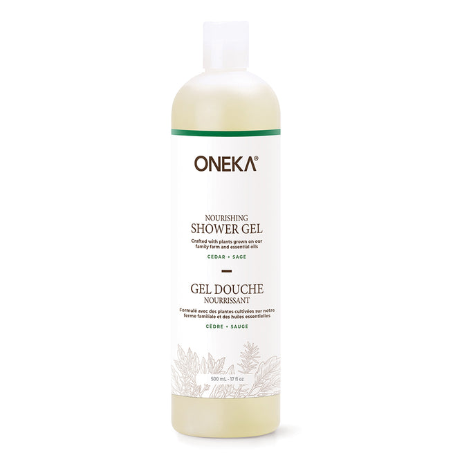 A white bottle of Oneka Shower Gel - Cedar & Sage features a minimalist label with green plant illustrations and bilingual text. This organic gel offers pH-balancing care in every nourishing wash.