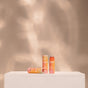 Three orange tubes of ATTITUDE mineral sunscreen SPF 30 stand on a white pedestal against a soft beige backdrop. Two are upright, one is horizontal—perfectly complemented by Oceanly PHYTO-SUN Lip Balm SPF30 for complete sun protection.