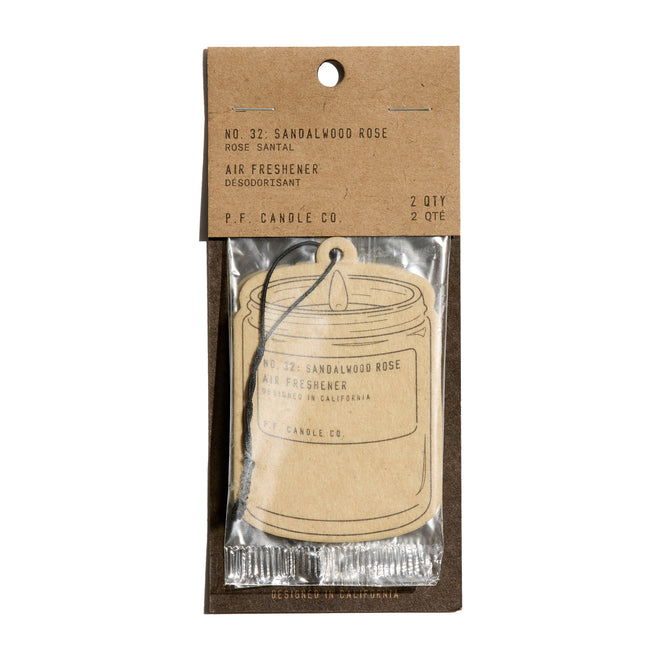 The P.F. Candle Co. Car Freshener in sandalwood rose scent comes in a clear plastic wrapper with a brown paper label, features a candle illustration, and instantly refreshes your space.