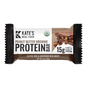 A wrapped Kate’s Real Food Organic Protein Bar—Peanut Butter Brownie—is USDA organic, gluten-free, and sweetened with honey. It provides 15g plant-based protein and clean energy, with a brownie image shown on the right of the package.