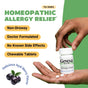 A person holds a GENEXA Allergy Care bottle featuring Homeopathic Allergy Medicine for Adults and benefits like non-drowsy, doctor formulated, no known side effects, and chewable tablets. Acai berries appear at the bottom.