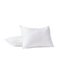 Two white Coyuchi Organic Crinkled Percale™ Shams, crafted from GOTS certified cotton, rest on a pristine white surface—one propped upright and the other lying flat behind it. The plain white background creates a clean, minimal aesthetic that accentuates the quality and softness of the organic percale beneath.