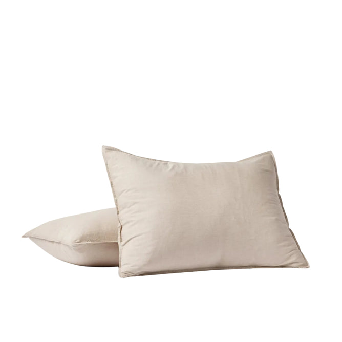 Two Coyuchi Organic Crinkled Percale™ Shams in beige are displayed on a white surface against a simple white background. One sham is propped upright while the other lies flat and slightly overlapping, highlighting the breathable comfort and soft, textured finish of the crinkled percale fabric.