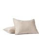 Two Coyuchi Organic Crinkled Percale™ Shams in beige are displayed on a white surface against a simple white background. One sham is propped upright while the other lies flat and slightly overlapping, highlighting the breathable comfort and soft, textured finish of the crinkled percale fabric.