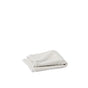 A neatly folded light gray Air Weight® Organic Towel from Coyuchi rests on a plain white surface, surrounded by ample empty space.