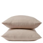 Two beige pillows stacked neatly on top of each other against a plain white background, each encased in Coyuchi’s Organic Crinkled Percale™ Pillowcases for a touch of natural comfort.