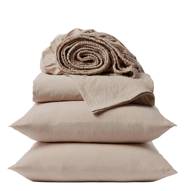 Two beige pillows are stacked with folded Coyuchi Organic Crinkled Percale™ Sheet Set and a rolled-up fitted sheet placed on top, set against a plain white background. This breathable bedding is crafted from GOTS-certified organic cotton for lasting comfort and peace of mind.