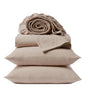 Two beige pillows are stacked with folded Coyuchi Organic Crinkled Percale™ Sheet Set and a rolled-up fitted sheet placed on top, set against a plain white background. This breathable bedding is crafted from GOTS-certified organic cotton for lasting comfort and peace of mind.
