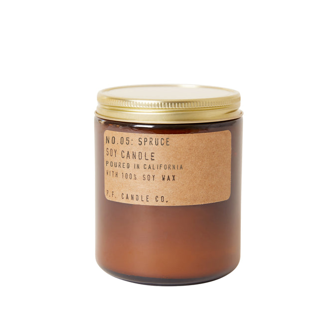 A brown glass jar with a gold lid, labeled Spruce - Limited Edition Soy Candle from P.F. Candle Co., sits against a white background.