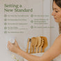 A person plugs a small, circular Enviroscent Plug-in Pet Air Freshener Starter Set - Odor Neutralizer into a wall outlet next to a list of product safety benefits titled Setting a New Standard.