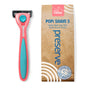 A coral and teal Preserve Recycled Ocean Plastic (POPi) Shave 5 Razor System sits beside brown packaging labeled “POPi SHAVE 5”, highlighting its handle made from 90% ocean-bound plastic. The package displays eco-friendly and premium shave icons, emphasizing the sustainable design of this razor by Preserve.
