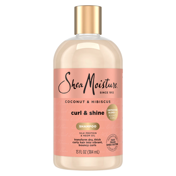 A 13 fl oz (384 mL) bottle of SheaMoisture Shampoo - Curl + Shine, featuring a peach label and gold cap, promotes frizz control and is specially formulated for thick, curly hair.
