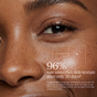 A close-up of a smiling person’s face reveals smooth, radiant skin—thanks to Andalou Naturals Resurfacing Gentle Glycolic Scrub with lactic acid and glycolic acid. On-screen text reads, “96% saw smoother skin texture after only 30 days*,” accompanied by a study disclaimer in small print below.