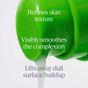 A green container labeled Andalou Naturals Resurfacing Overnight Glycolic Serum pours out white lotion. Overlaid text reads: Refines skin texture, visibly smoothes the complexion, and lifts away dull surface buildup with the power of a gentle fruit enzyme exfoliant.