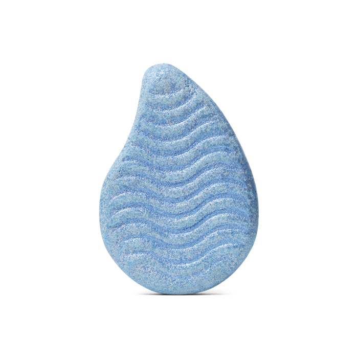 The Sand & Sea Bath Bomb by Pacha Soap Co. is a blue, teardrop-shaped bath bomb with a wavy, textured surface, evoking hand-crafted quality and scented with clary sage and sandalwood, displayed against a white background.