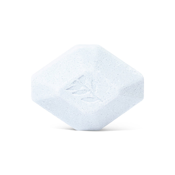 The Pacha Soap Co. Sleep Epsom Salt Bath Bomb is a white, hexagonal tablet with beveled edges and a leaf imprint, ideal for aromatherapy and relaxation. Shown on a plain white background.