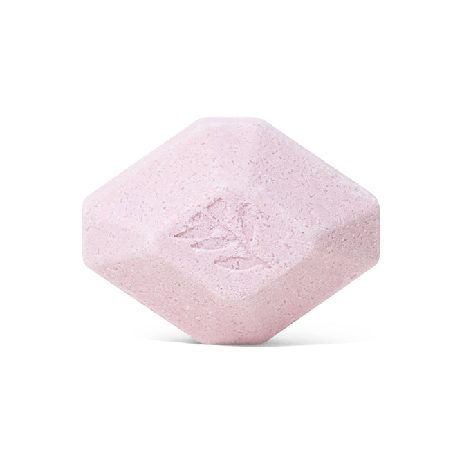 A single, light pink, hexagonal Sleep Epsom Salt Bath Bomb by Pacha Soap Co., featuring beveled edges and an embossed leaf design—perfect for aromatherapy—displayed against a white background.