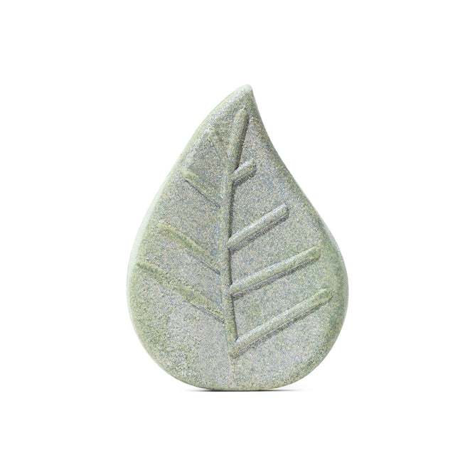 A smooth, greenish Vanilla & Sage Bath Bomb by Pacha Soap Co. shaped like a water droplet with a carved leaf vein pattern, evoking calming herbal scents. Displayed against a plain white background.