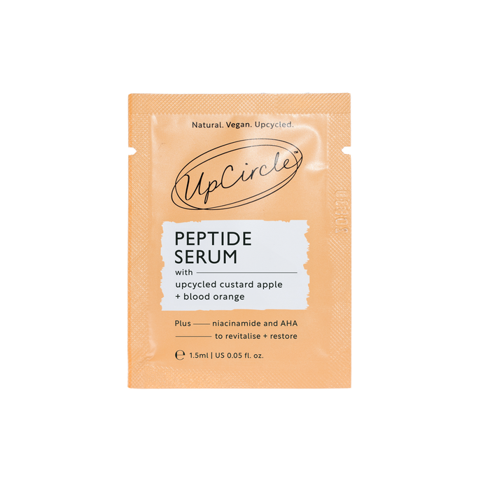 Orange sachet labeled UpCircle Peptide Serum - Sample with upcycled custard apple and blood orange. Features niacinamide and AHA to revitalize, boost collagen, and restore. Text reads Natural. Vegan. Upcycled. Size: 1.5ml/0.05 fl oz.