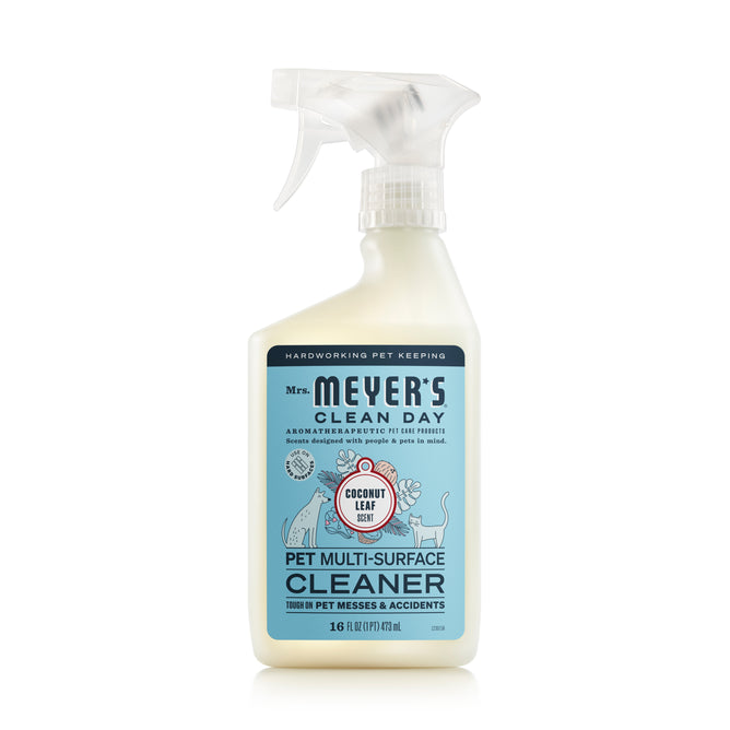 A 16 fl oz (473 mL) spray bottle of Mrs. Meyers Pet Multi-Surface Cleaner features a coconut leaf scent and probiotic micro-helpers for odor-neutralizing power against pet messes, with white packaging and blue accents.