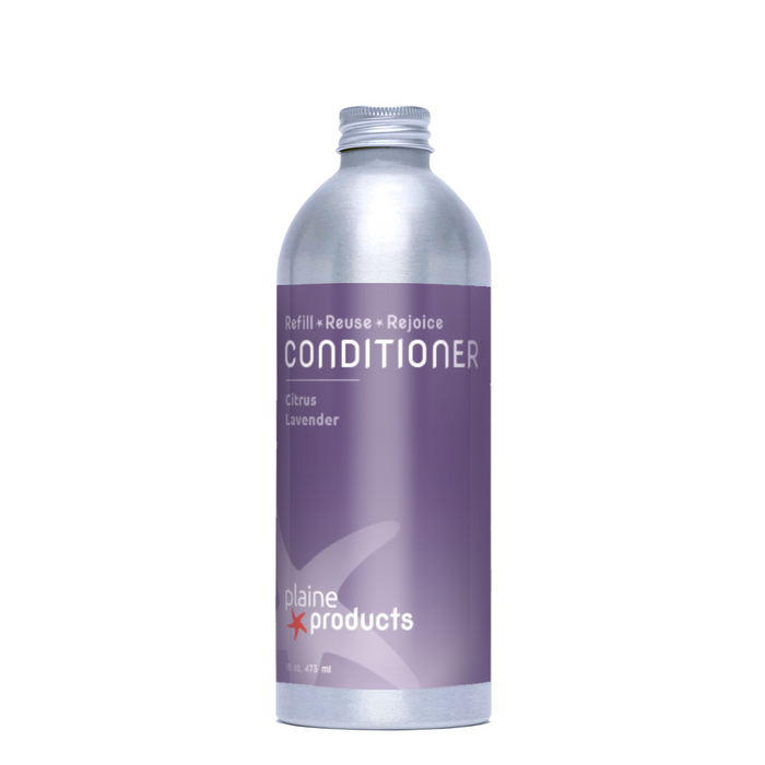 A silver aluminum bottle labeled Conditioner, Citrus Lavender by Plaine Products sits on a purple background, promoting vegan hair hydration with a refreshing citrus-lavender scent and the message: Refill + Reuse + Rejoice.