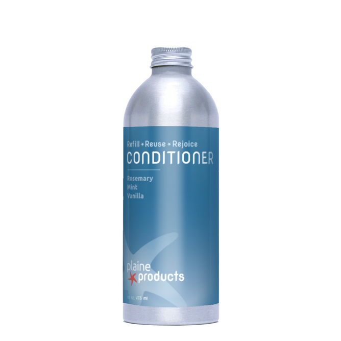 A silver aluminum Plaine Products Conditioner bottle with a blue label reads "Refill • Reuse • Rejoice" and lists the rosemary mint vanilla scent, designed for scalp balance and vegan-friendly.