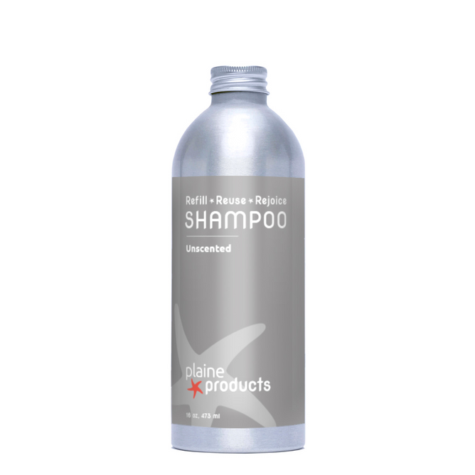 A silver aluminum bottle labeled Shampoo, Unscented from Plaine Products, featuring "Refill • Reuse • Rejoice" in white and red text. This vegan shampoo comes with a screw cap and provides gentle, moisturizing hair care.