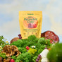 A bag of Plant People WonderDay - Super Mushroom Gummies stands upright outdoors among functional mushrooms, green moss, and small flowers, with a bright blue sky and soft clouds in the background.