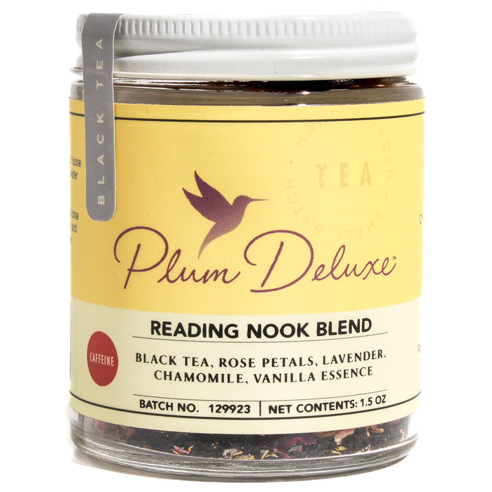 A jar of Plum Deluxe Reading Nook Lavender Rose Chamomile Tea, with a yellow label and hummingbird logo. Ingredients: black tea, rose petals, lavender, chamomile, and creamy vanilla essence.