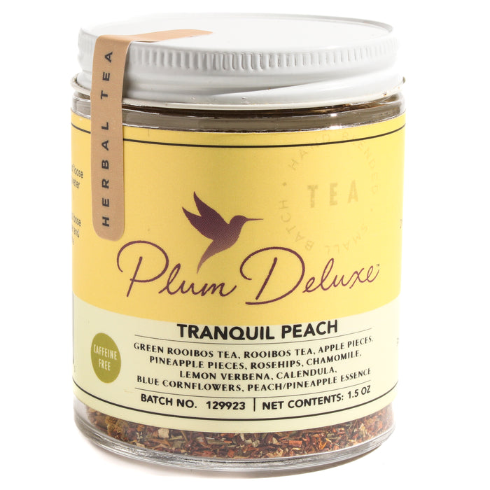 A jar of Plum Deluxe Tranquil Peach Tea, a caffeine-free blend with rooibos, apple pieces, pineapple, rosehips, chamomile, lemon verbena, calendula, and blue cornflowers.
