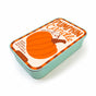 The Neighborgoods Soy Wax Candle in a rectangular sardine tin with a Pumpkin Candle label, featuring a pumpkin illustration and the text Warm pumpkin spice with a hint of vanilla.