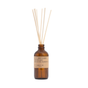 A P.F. Candle Co. Reed Diffuser in a brown amber glass bottle labeled "Amber & Moss" with several natural wooden reeds extending from the top, providing a flame-free fragrance solution, displayed against a white background.