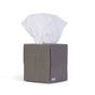 A gray, cube-shaped box of Reel Premium Bamboo Facial Tissues (60 3-ply per box) with one white tissue pulled from the top features an embossed "r" and “reel” printed on the lower corner.