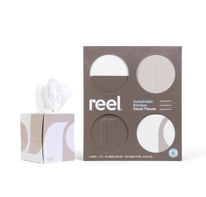 A box of Reel Premium Bamboo Facial Tissues (60 3-ply tissues per box) sits by the packaging, which features circular cutouts showing the sustainable, hypoallergenic, and fragrance-free tissues inside.