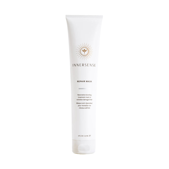 A white tube of Innersense Organic Beauty Repair Mask with gold and black accents displays branding and product info. This treatment targets split ends and damaged hair. The upright tube is shown against a plain white background.