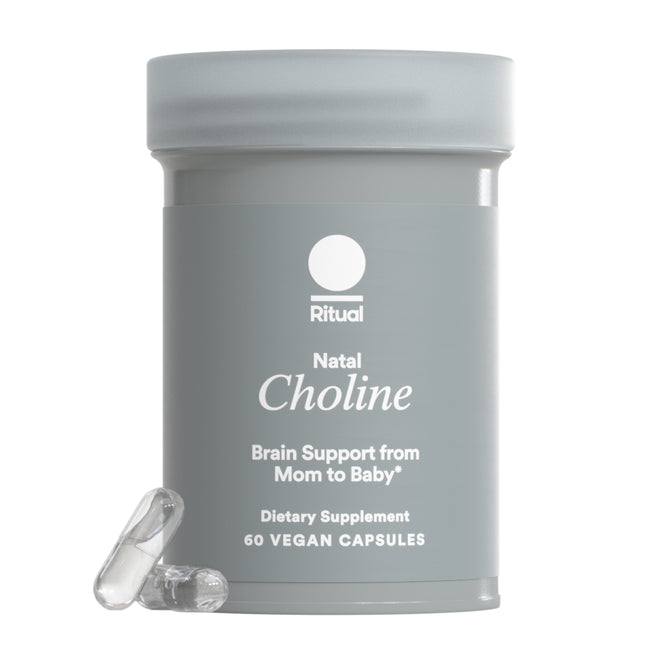 A gray bottle of Ritual Natal Choline, labeled Brain Support from Mom to Baby, contains 60 vegan capsules for prenatal brain support. Two clear capsules are displayed in front.