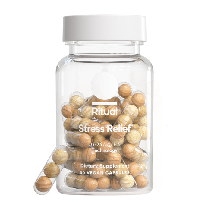 Ritual Stress Relief is a clear bottle with a white cap, containing 30 vegan capsules of speckled brown and beige ashwagandha powder for stress management in clean, simple packaging.