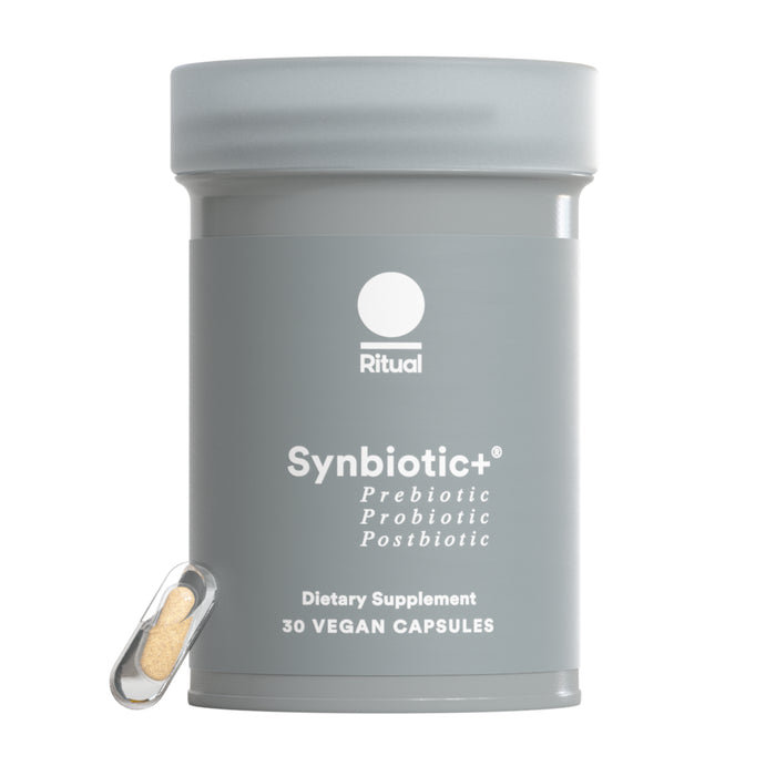 A gray Ritual Synbiotic+ container labeled "Prebiotics Probiotics Postbiotic dietary supplement" with "30 vegan capsules" below, supports your gut microbiome. A single clear capsule of tan powder sits beside the container.