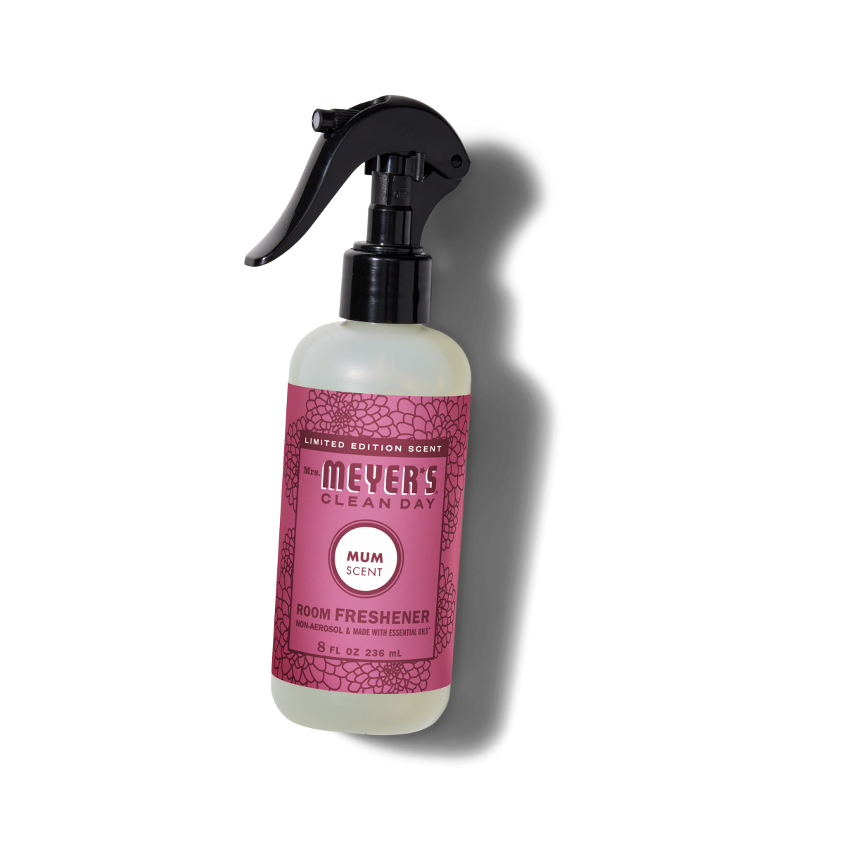 A bottle of Mrs. Meyers Clean Day Room Freshener in Mum Scent, featuring a pink label with floral patterns and a black spray nozzle, standing upright on a white background.