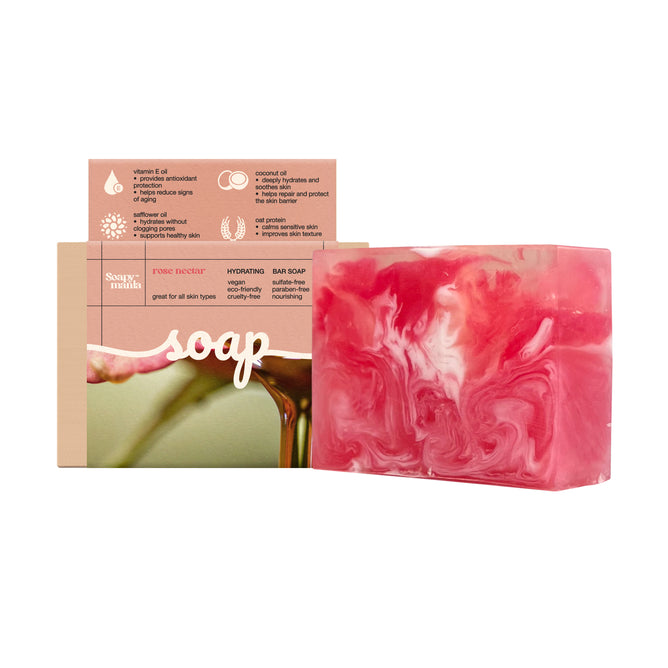 Soapymania’s Rose Nectar Hydrating Bar Soap, with a pink and white marbled design, is shown in front of its box, which highlights natural vegan ingredients and claims it hydrates, nourishes, and suits all skin types.
