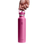 A hand holds a pink Hydro Flask Standard Mouth Bottle with Flex Straw Cap, 24 oz, by the loop handle on a white background. The bottle displays the Hydro Flask logo and features TempShield insulation to keep drinks at the perfect temperature for hours.
