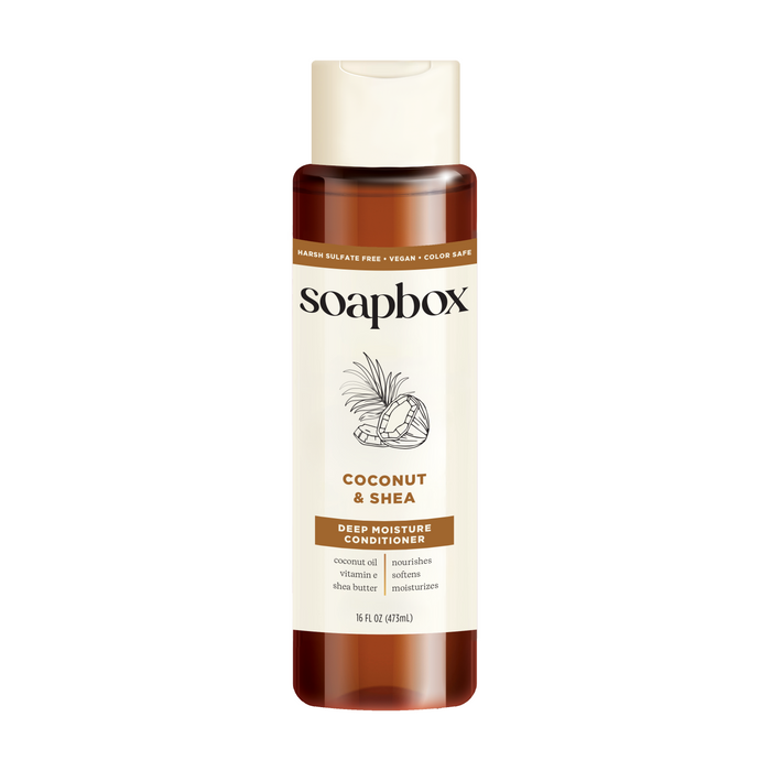 A bottle of Soapbox Coconut & Shea Deep Moisture Conditioner with a white label, beige cap, and illustrations of coconut and shea. Text highlights coconut oil, shea butter, vegan formula, and 16 fl oz size.