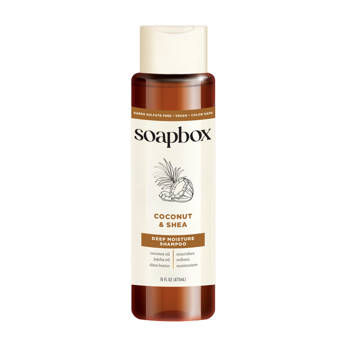 A bottle of Soapbox Coconut & Shea Deep Moisture Shampoo with a beige label, coconut and shea illustrations, and text highlighting coconut oil and shea butter ingredients; 16 fl oz size.