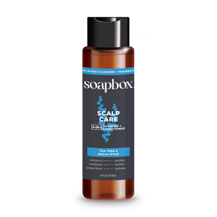 A 16 fl oz (473 ml) bottle of Soapbox Scalp Care 2-in-1 shampoo and conditioner, featuring tea tree, eucalyptus, mint, and juniper berry for fuller hair. The sulfate-free formula comes in a brown bottle with a black cap and blue label.