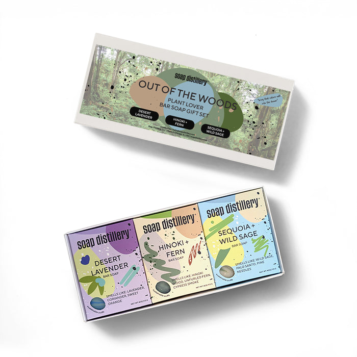Soap Distillery’s Out of the Woods Three Soap Gift Set features three nature-inspired bar soaps—Desert Lavender, Hinoki + Fern, and Sequoia + Wild Sage—in pastel packaging decorated with plant illustrations.